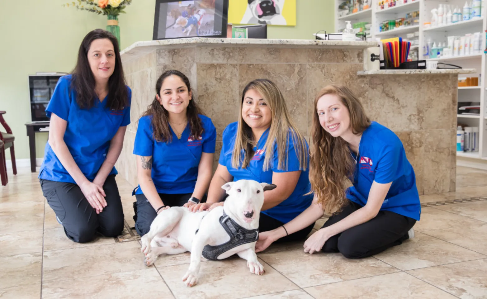 Staff members at The Animalife Veterinary Center at Mission Hills with a white dog